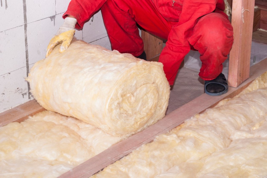 A person laying down insulation